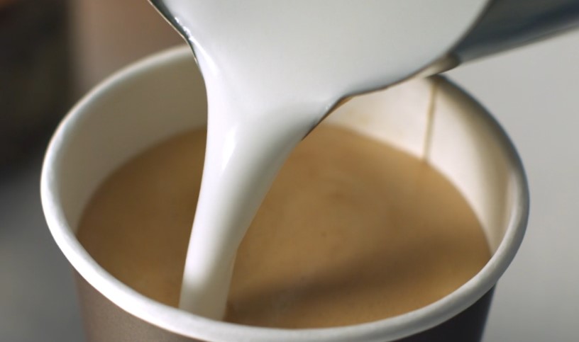 Presipanje mleka iz posude u šolju kafe